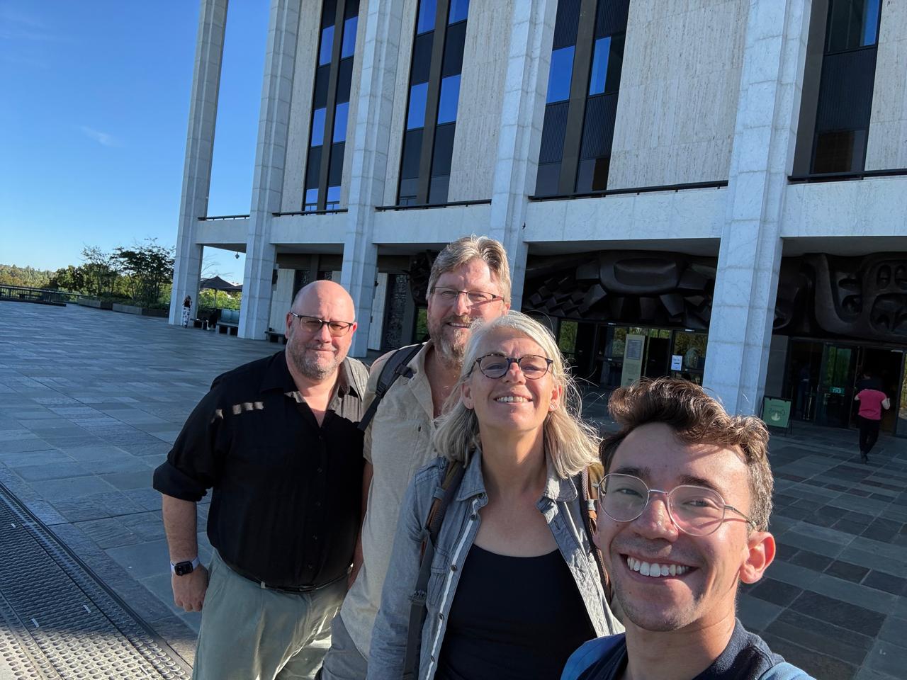 Group of four people posing together in front of Australian National University in Canberra.